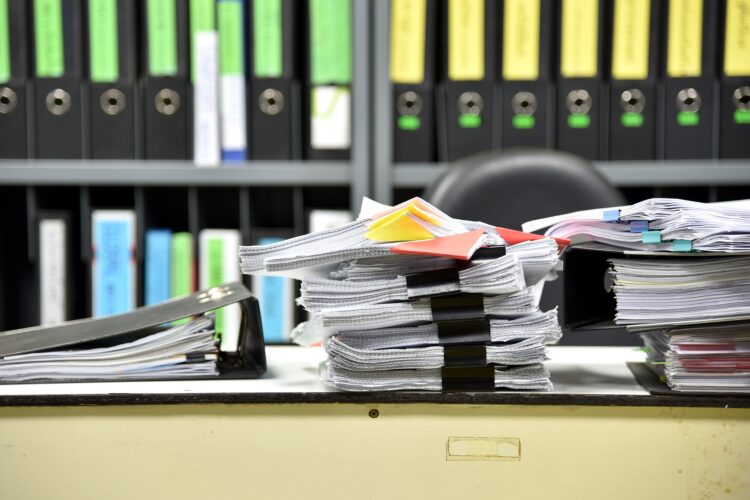 Stacks of document paper and files folder on office desk